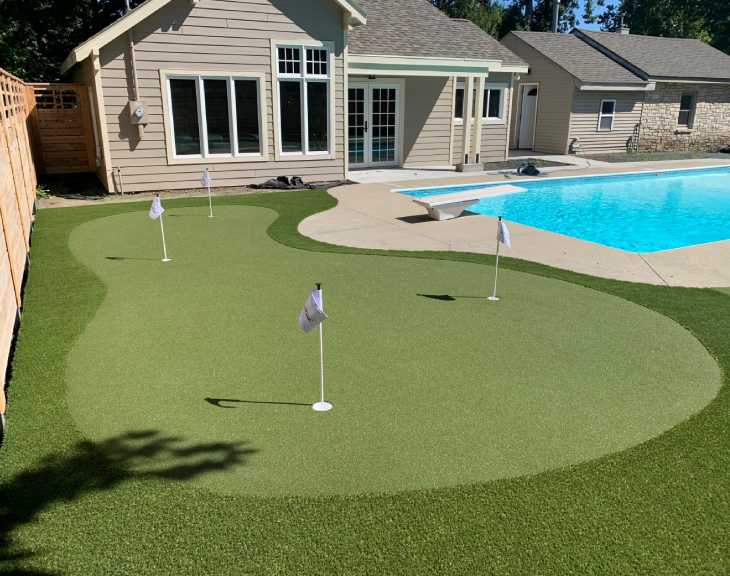 Backyard golf green installed on patio by pool